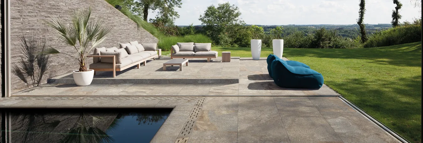 R12 slip-resistant stone look outdoor porcelain tiles on a terrace and pool surround with outdoor furniture