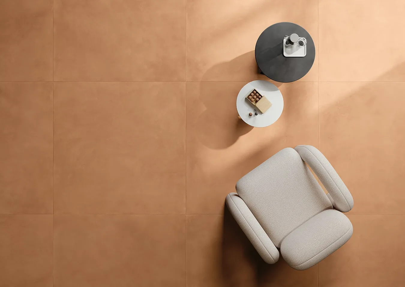 Cozy living room with handmade-look terracotta floor tiles and modern armchair.