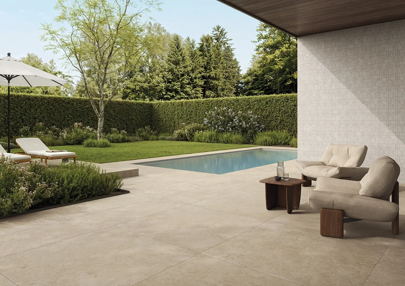 Terrasse extérieure avec dalles en grès cérame autour d'une piscine, carrelage mural assorti et mobilier lounge