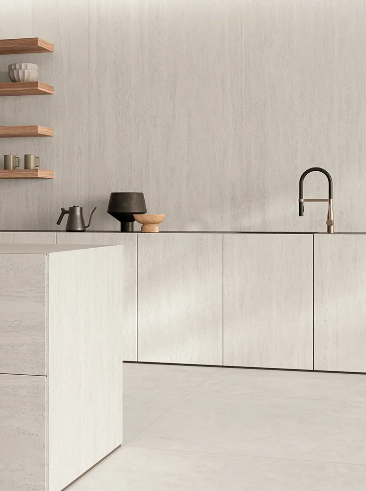 Azulejo de gres porcelánico efecto travertino con acabado ULTRAsilky en pared e isla de cocina en un interior contemporáneo minimalista