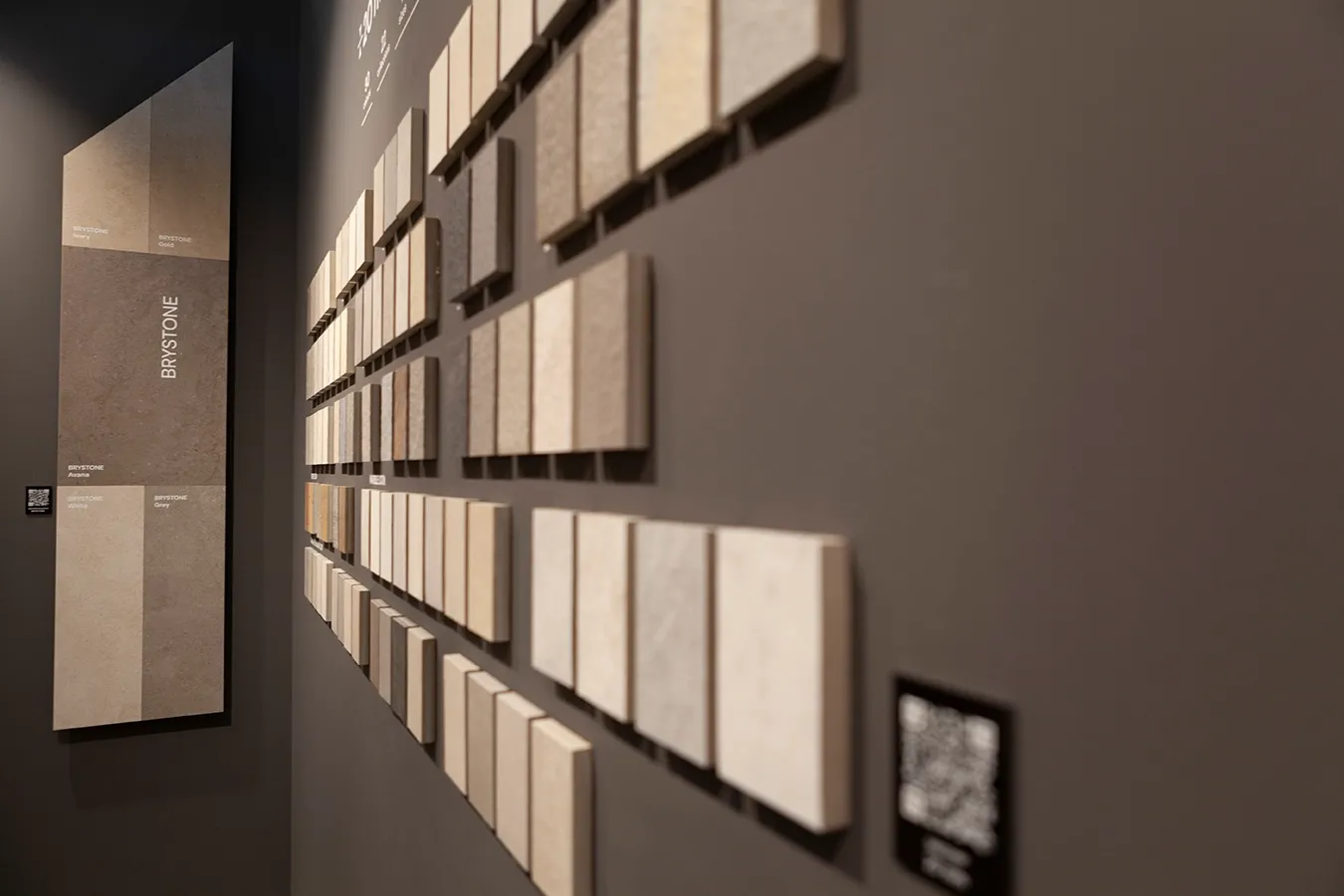 Detailed view of concrete-look porcelain tile samples in dusty urban tones and matte finishes on display at Cersaie.