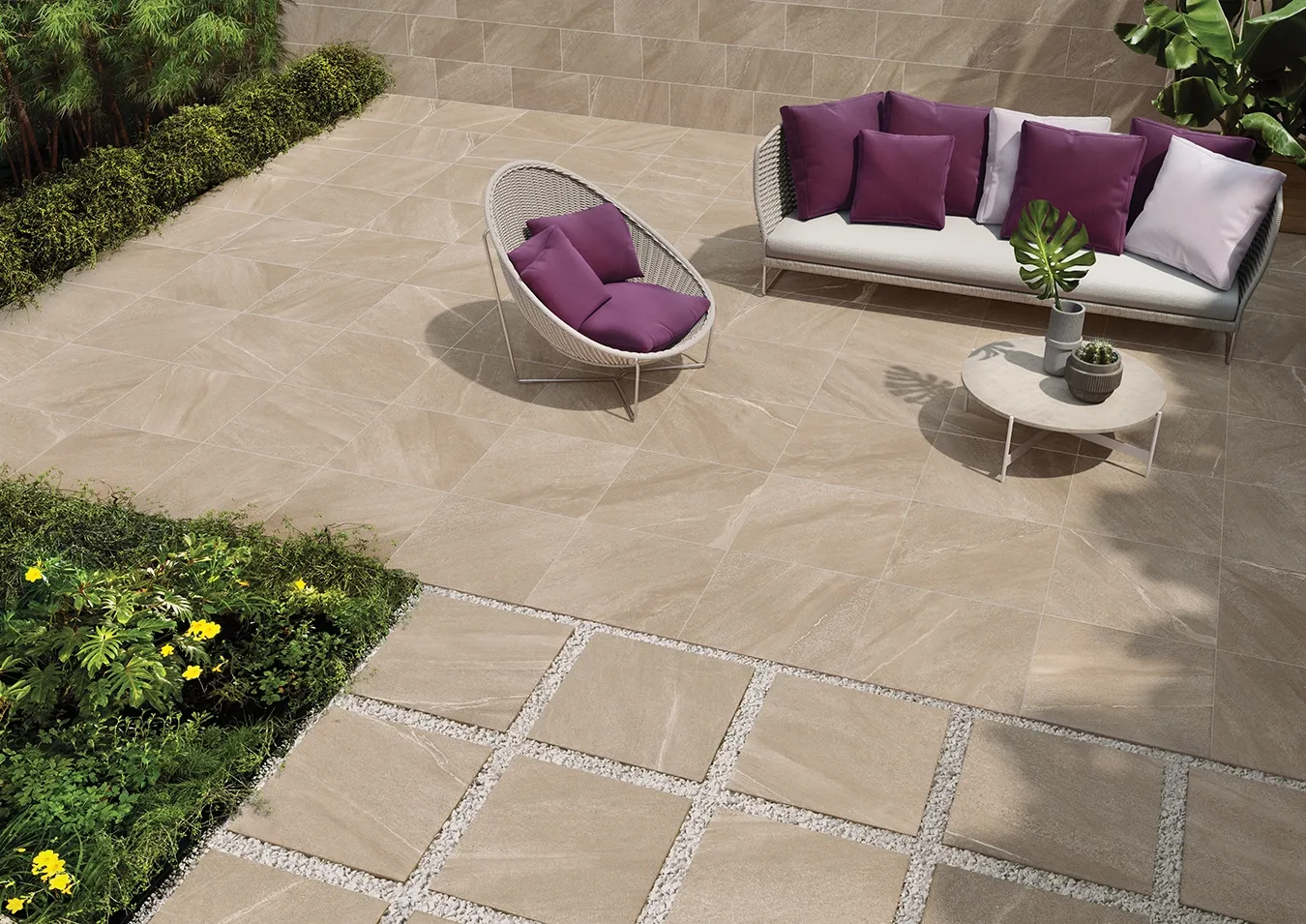 Baldosas de gres porcelánico efecto piedra beige con acabado Structured R11 en patio exterior con colocación en seco sobre grava