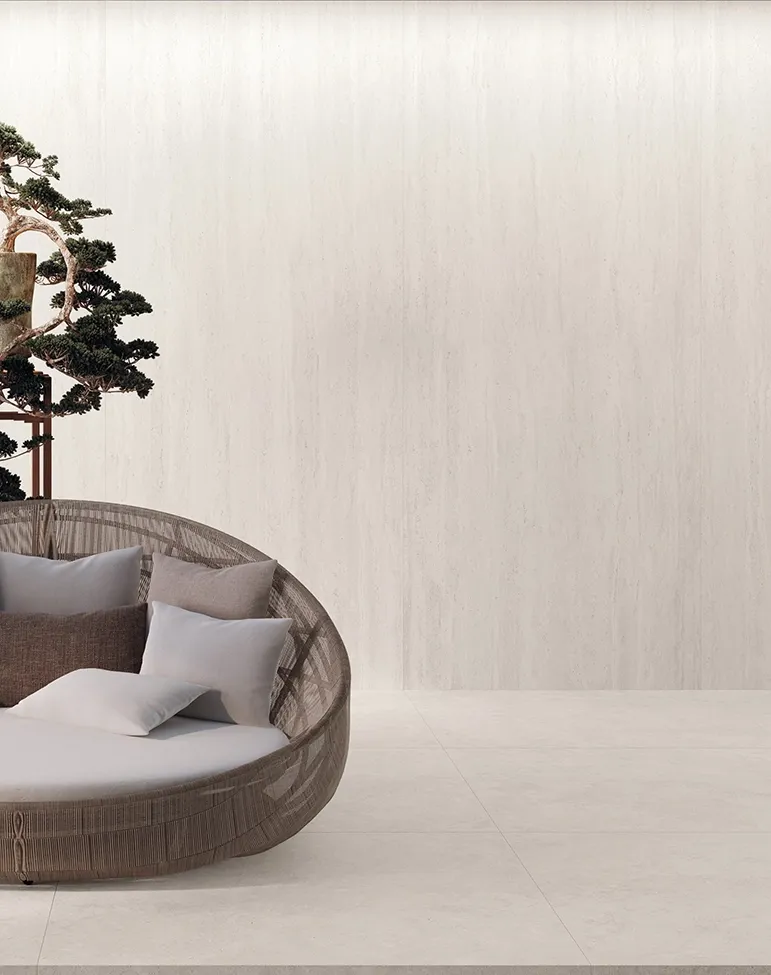 Piastrelle in gres travertino in falda con motivi circolari su parete e pavimento del soggiorno.