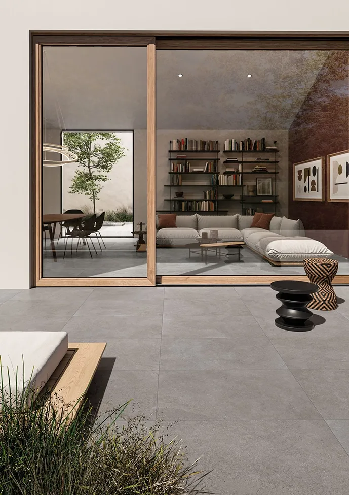 Carrelage grand format en grès cérame effet pierre calcaire gris du salon à la cour extérieure