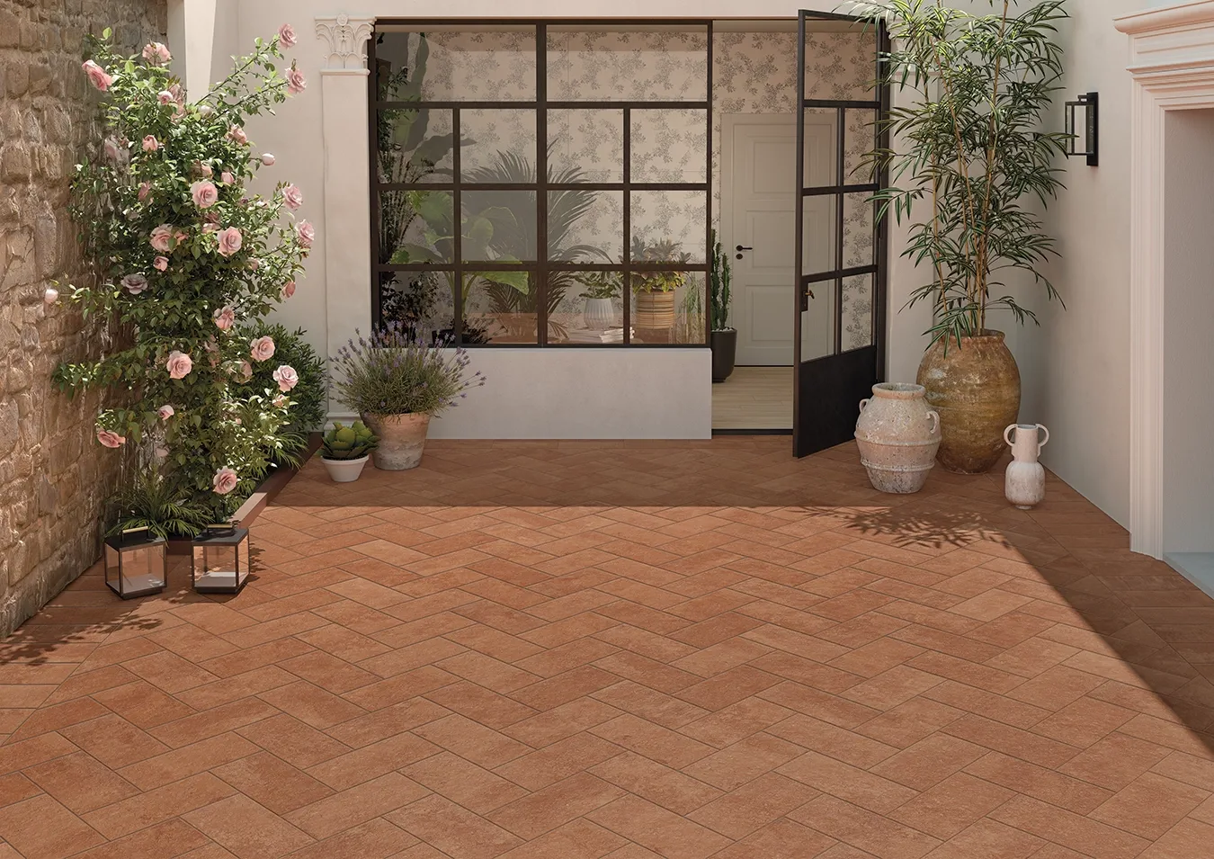 Patio featuring terracotta look tiles in a herringbone pattern meeting entryway wood look tiles in regular laying.
