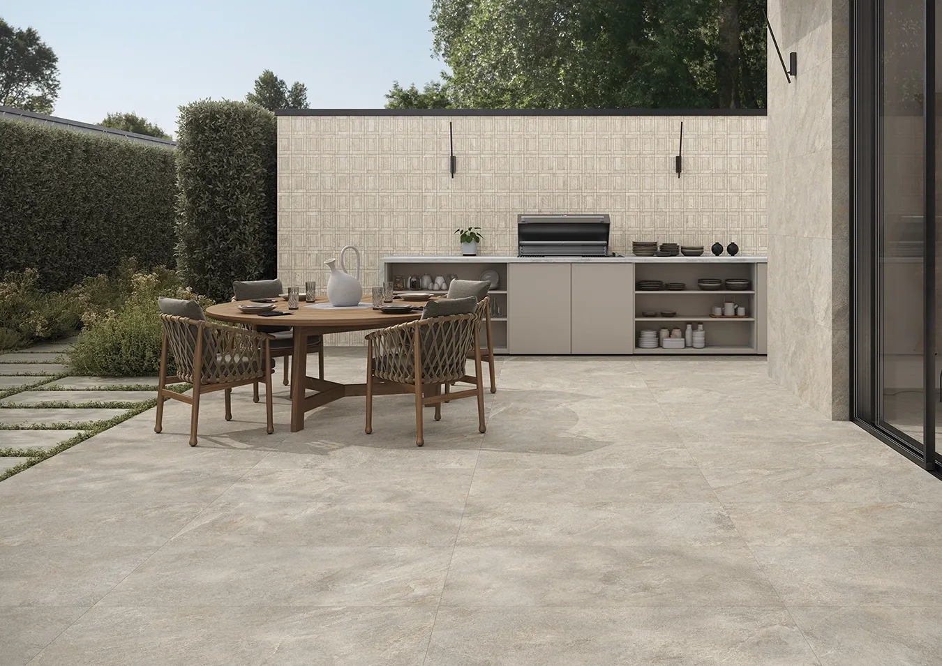 Dalles en grès cérame effet pierre sur une terrasse avec salle à manger et cuisine extérieure